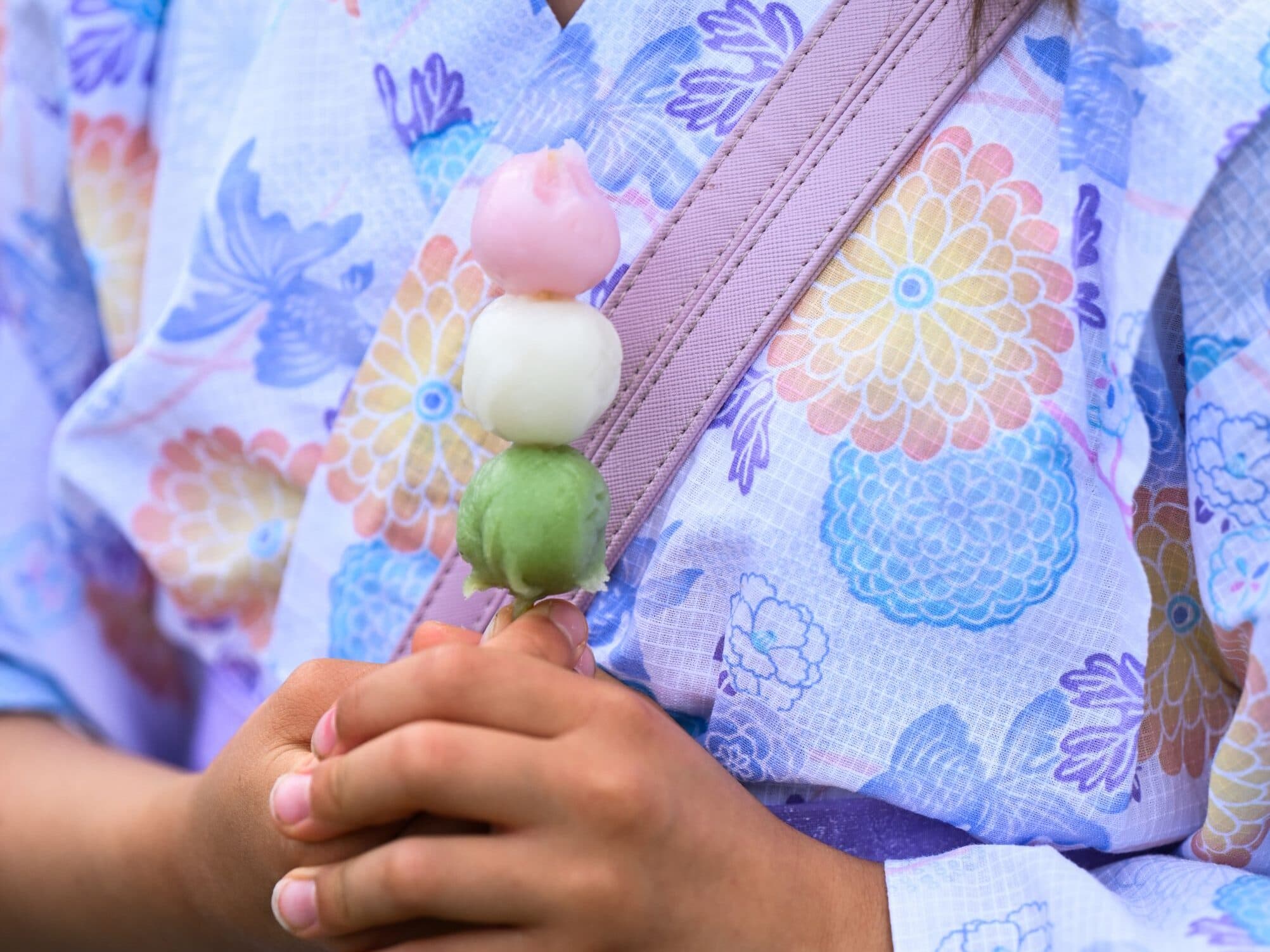 Visitor wearing a yukata and holding traditional Japanese dango at the Canberra Nara Candle Festival.